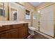 Bathroom featuring a large vanity with oak cabinets, a sink, and a shower behind a glass door at 8547 Benidorm Ave, Las Vegas, NV 89178