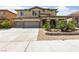 Beautiful two-story home with a three-car garage, a stone facade, and lush front yard landscaping at 8547 Benidorm Ave, Las Vegas, NV 89178