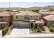 Two-story home featuring a three-car garage and desert landscaping at 8547 Benidorm Ave, Las Vegas, NV 89178