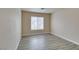 A well-lit bedroom featuring neutral walls, wood-look floors, and a window for natural light at 8675 Traveling Breeze Ave # 101, Las Vegas, NV 89178