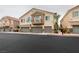 Two-story townhouse featuring private balconies, and two-car garages with stone accents at 8675 Traveling Breeze Ave # 101, Las Vegas, NV 89178