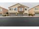 Two-story townhouse featuring private balconies, and two-car garages with stone accents at 8675 Traveling Breeze Ave # 101, Las Vegas, NV 89178