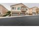 Two-story townhouse featuring private balconies, and two-car garages with stone accents at 8675 Traveling Breeze Ave # 101, Las Vegas, NV 89178
