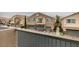 View of the townhome exteriors with multiple garages, small balconies, and well-kept landscaping at 8675 Traveling Breeze Ave # 101, Las Vegas, NV 89178
