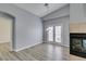 Open-concept living room with vaulted ceilings, a modern fireplace, and doors to the outside at 8675 Traveling Breeze Ave # 101, Las Vegas, NV 89178