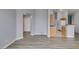 Living room with wood-look floors, view to kitchen and hallway at 8675 Traveling Breeze Ave # 101, Las Vegas, NV 89178