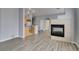 Inviting living room with light gray walls, fireplace, and light wood laminate flooring throughout at 8675 Traveling Breeze Ave # 101, Las Vegas, NV 89178