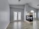 Open-concept living room with vaulted ceilings, a modern fireplace, and doors to the outside at 8675 Traveling Breeze Ave # 101, Las Vegas, NV 89178