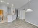 Open living room with wood-look floors and view to kitchen with white appliances and light wood cabinets at 8675 Traveling Breeze Ave # 101, Las Vegas, NV 89178