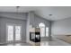 Open-concept living room with vaulted ceilings, a modern fireplace, and doors to the outside at 8675 Traveling Breeze Ave # 101, Las Vegas, NV 89178