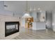 Living room with fireplace and wood-look floors, view to kitchen with stainless appliances at 8675 Traveling Breeze Ave # 101, Las Vegas, NV 89178