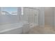 Bathroom with a soaking tub and a glass-enclosed shower, accented by neutral-toned tile flooring at 888 Cherry Glen Pl, Las Vegas, NV 89138
