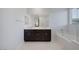 Luxurious bathroom featuring a double vanity, a large mirror, and a soaking tub with tile surround at 888 Cherry Glen Pl, Las Vegas, NV 89138