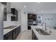Modern kitchen features stainless steel appliances, dark cabinets, and a center island with sink and faucet at 888 Cherry Glen Pl, Las Vegas, NV 89138