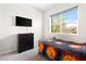 Neutral bedroom with a mounted television and a bright window with a view to the community at 8929 Cassia Winds St, Las Vegas, NV 89166