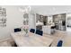 Open dining area view into the modern kitchen with a white quartz island with seating at 8929 Cassia Winds St, Las Vegas, NV 89166