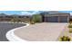 Paver driveway leading to a well-manicured home with desert landscaping at 8929 Cassia Winds St, Las Vegas, NV 89166