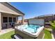 Backyard featuring a in-ground hot tub, covered patio, and artificial grass at 8929 Cassia Winds St, Las Vegas, NV 89166