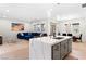 Open concept living space with blue sectional sofa, dining table, and kitchen island at 8929 Cassia Winds St, Las Vegas, NV 89166