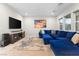 Bright living room with large blue sectional, TV, and decorative rug at 8929 Cassia Winds St, Las Vegas, NV 89166