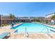 Community pool featuring lounge chairs, umbrellas, and well-maintained landscaping at 8929 Cassia Winds St, Las Vegas, NV 89166