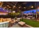 Cozy backyard with a covered patio, string lights, comfortable seating, and manicured lawn at 9013 Cypress Point Way, Las Vegas, NV 89117