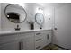 Bright bathroom featuring double sinks with white countertop and decorative round mirrors at 9013 Cypress Point Way, Las Vegas, NV 89117