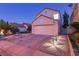 Front exterior of a home with a two-car garage, manicured landscaping, and appealing nighttime lighting at 9013 Cypress Point Way, Las Vegas, NV 89117