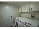Functional laundry room features a washer, dryer, and white cabinets for storage at 9013 Cypress Point Way, Las Vegas, NV 89117