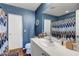 Bathroom with a large mirror, white vanity, toilet, and a shower with a decorative curtain at 9065 Adorable Ave, Las Vegas, NV 89149