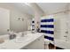 Bright bathroom featuring a single sink vanity and a shower-tub combination with a striped curtain at 9065 Adorable Ave, Las Vegas, NV 89149