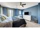 Spacious bedroom featuring blue walls, carpet flooring, and window with natural light at 9065 Adorable Ave, Las Vegas, NV 89149