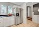 Well-maintained kitchen featuring stainless steel appliances, white cabinets, tile flooring and view of stairs at 9065 Adorable Ave, Las Vegas, NV 89149