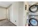 Efficient laundry area with stacked washer and dryer units and storage shelves in a hallway at 9065 Adorable Ave, Las Vegas, NV 89149