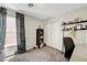 Bright room with large windows and curtains, a black bookshelf, and a gray office chair at 9065 Adorable Ave, Las Vegas, NV 89149