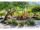 Community playground with play structures, surrounded by trees and well-maintained landscaping at 9065 Adorable Ave, Las Vegas, NV 89149
