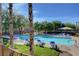 Community pool with lounge chairs, palm trees, and shade umbrellas for relaxing on hot summer days at 9065 Adorable Ave, Las Vegas, NV 89149