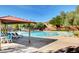 Resort-style pool area with lounge chairs, a covered patio, and mature landscaping for relaxing summer days at 9065 Adorable Ave, Las Vegas, NV 89149