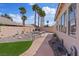 Landscaped backyard featuring a brick walkway, mature palm trees, and decorative rock features at 9096 Nomo St, Las Vegas, NV 89123