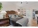 Comfortable bedroom with an ornate headboard, ensuite bathroom, and decorative shelving at 9096 Nomo St, Las Vegas, NV 89123