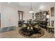 Elegant dining room showcasing a unique round table set, black lacquered furniture, and stylish chandelier at 9096 Nomo St, Las Vegas, NV 89123