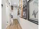 Bright hallway with wood floors leading to a bathroom and adorned with decorative artwork at 9096 Nomo St, Las Vegas, NV 89123