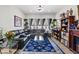 Spacious living room featuring backyard views, a black sectional sofa, blue rug, and built-in bookshelves at 9096 Nomo St, Las Vegas, NV 89123