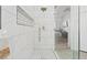 Elegant walk-in shower with white marble tile, rain shower head, niche, and mosaic tile flooring at 9096 Nomo St, Las Vegas, NV 89123