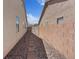 Narrow side yard with a walkway, low-maintenance landscaping, and privacy fencing at 9096 Nomo St, Las Vegas, NV 89123