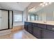 Bathroom featuring a double sink vanity, a bathtub, and a glass-enclosed shower at 9780 Ziegler Ave, Las Vegas, NV 89148