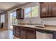 Kitchen with granite counters, dark cabinets, and stainless-steel dishwasher and sink at 9780 Ziegler Ave, Las Vegas, NV 89148