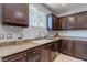 Kitchen with granite counters, dark cabinets, a window, and stainless-steel dishwasher at 9780 Ziegler Ave, Las Vegas, NV 89148