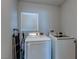 Modern laundry room featuring a side-by-side washer and dryer, and shelving for storage of supplies at 9780 Ziegler Ave, Las Vegas, NV 89148