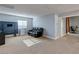 Cozy living room with a black leather sofa, carpeted flooring, and natural light from the window at 9780 Ziegler Ave, Las Vegas, NV 89148